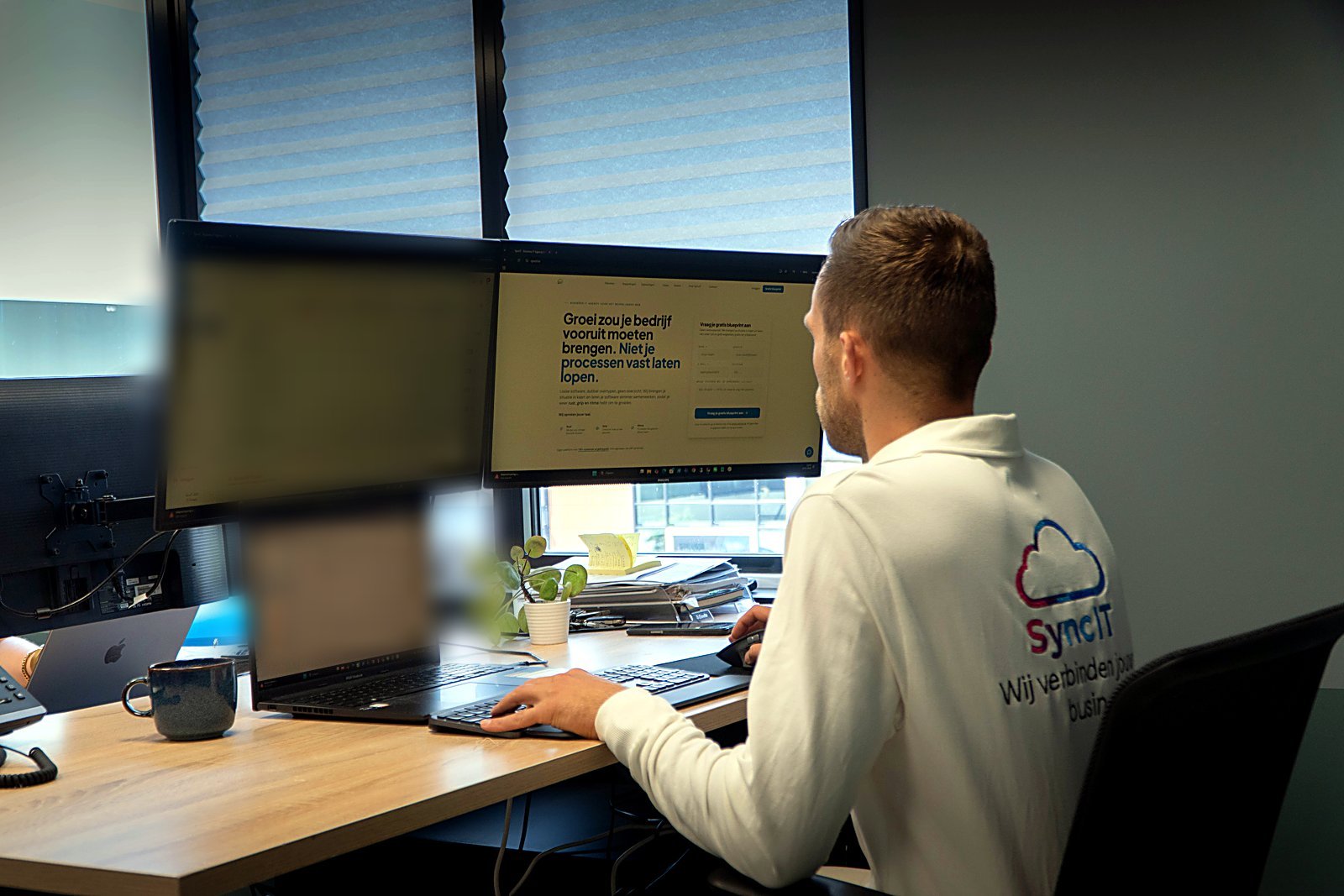 Een SyncIT-medewerker aan het werk achter de schermen op het eigen platform